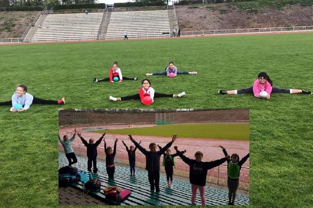 Sechs Kinder dehnen sich auf einem Rasenplatz, während zwei weitere in einer unteren Bildhälfte jubeln.