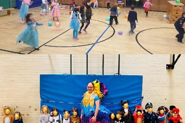 Kinder in Kostümen spielen mit bunten Ballons in einer Sporthalle, während eine Gruppe verkleideter Kinder und ein Erwachsener posieren.