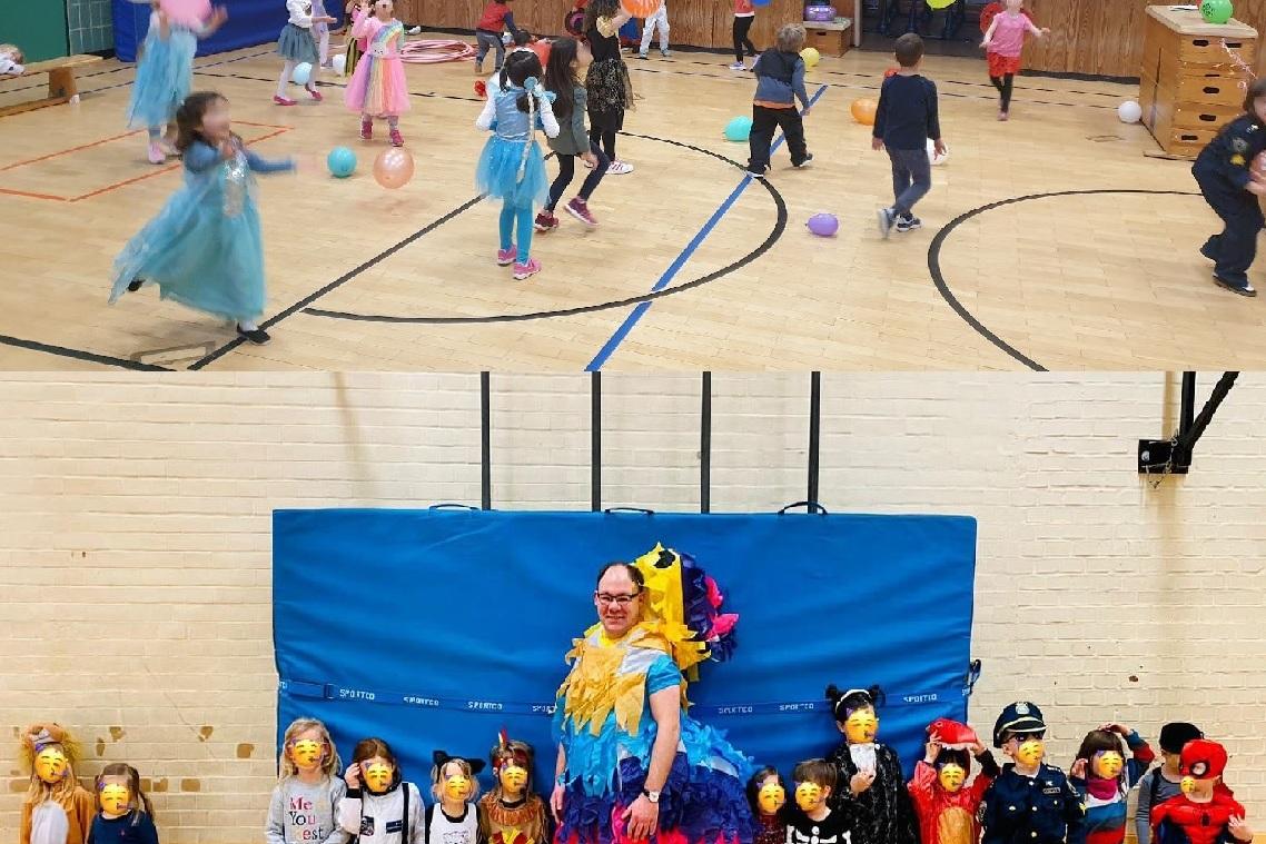 Kinder in Kostümen spielen mit bunten Ballons in einer Sporthalle, während eine Gruppe verkleideter Kinder und ein Erwachsener posieren.