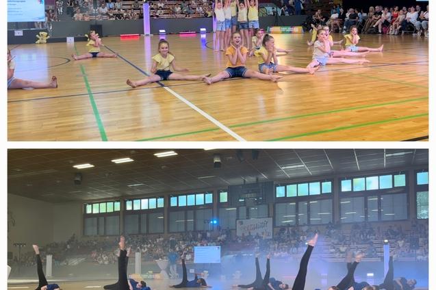 Tanzaufführung in einer Sporthalle mit Gruppen von Tänzerinnen in gelben und blauen Outfits auf Parkettboden.