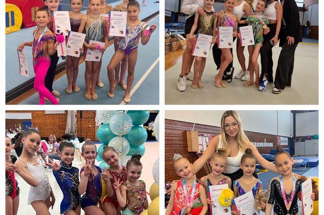 Gruppe von jungen Turnerinnen in bunten Kostümen mit Urkunden, posierend in einer Turnhalle.