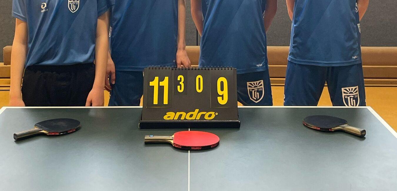 Gruppenfoto von vier jungen Menschen in Trikot hinter einer Tischtennisplatte