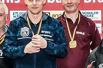 Fünf Tischtennisspieler stehen mit Medaillen vor einem roten Hintergrund, lächeln und zeigen ihre Erfolge.