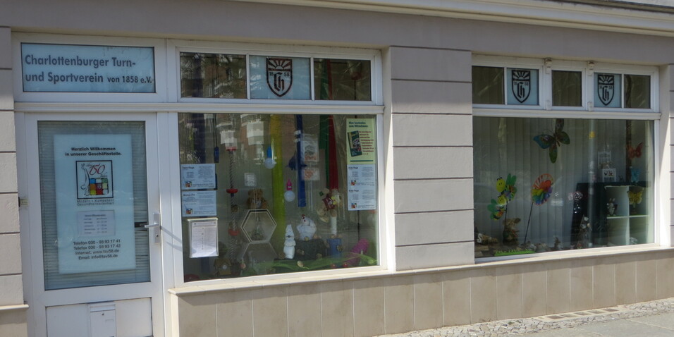 Eingang des Charlottenburger Turn- und Sportvereins mit Schaufenster und bunten Dekorationen.