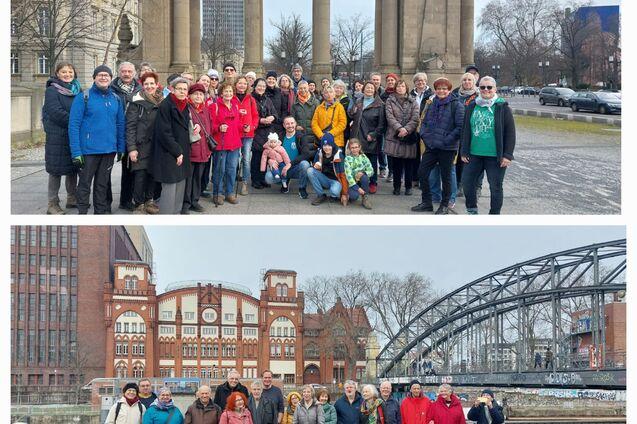 Gruppenfoto von etwa 40 Personen vor einem historischen Gebäude und einer Brücke in einer urbanen Umgebung.