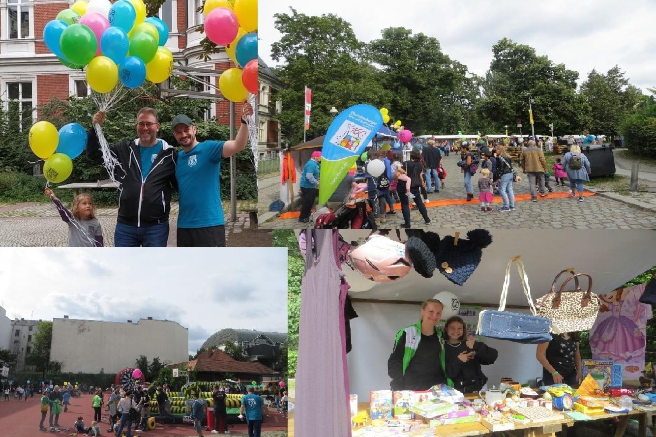 Menschen auf einem Fest halten Luftballons; Stände mit Spielen und Angeboten, viele Familien und Kinder im Hintergrund.