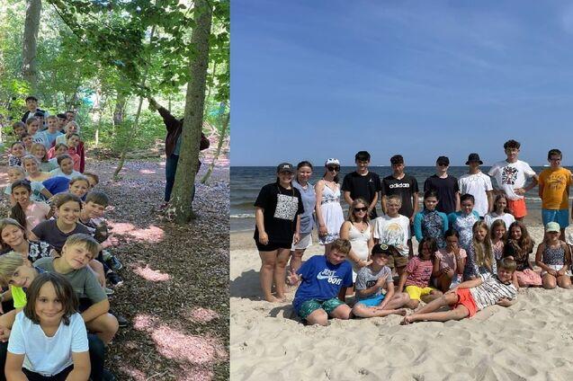 Gruppenfoto von Kindern und Jugendlichen am Strand, umgeben von Wasser und Sand, unter blauem Himmel.